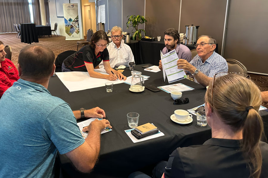 People at table discussing a topic and writing ideas on paper