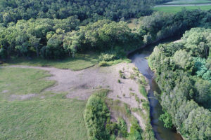 Reef Trust 4, Mackay, aerial view of avulsion of creek bank due to poor deep rooted vegetation on the bank, resulting in loss of productive land.