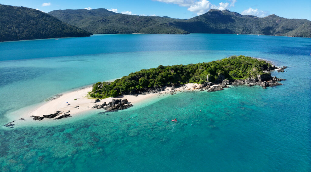 WRII banner image = drone shot of black island surrounded by blue water with fringing reel
