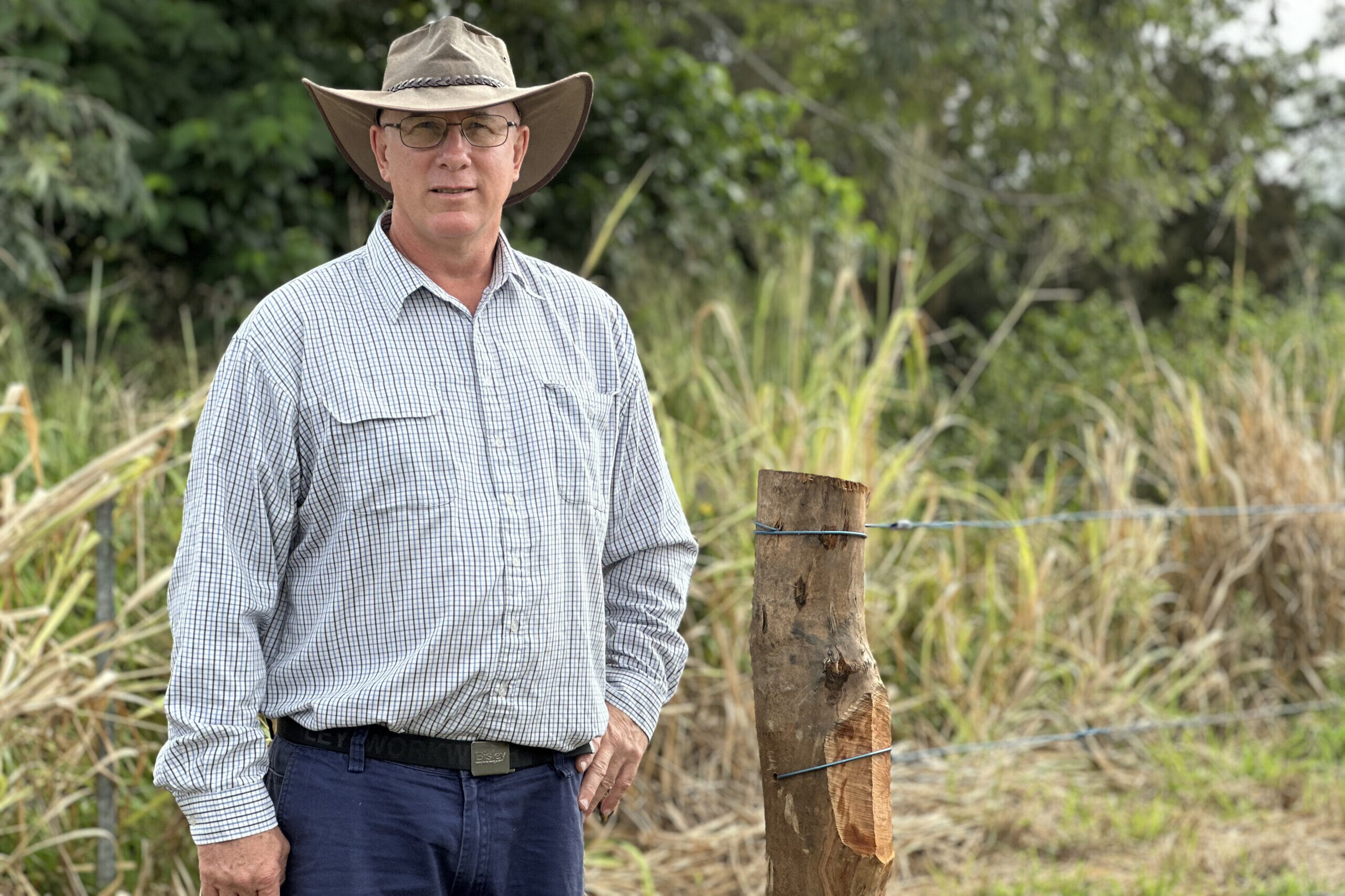 Landholder standing in front of a wire fence