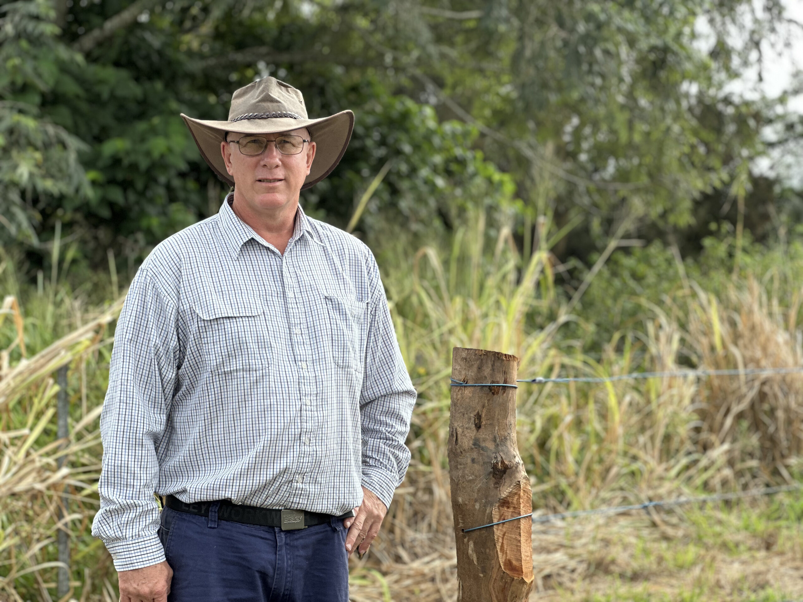 Landholder standing in front of a wire fence
