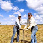 Reef Catchments Sustainable Agriculture team members using tool to extract soil sample