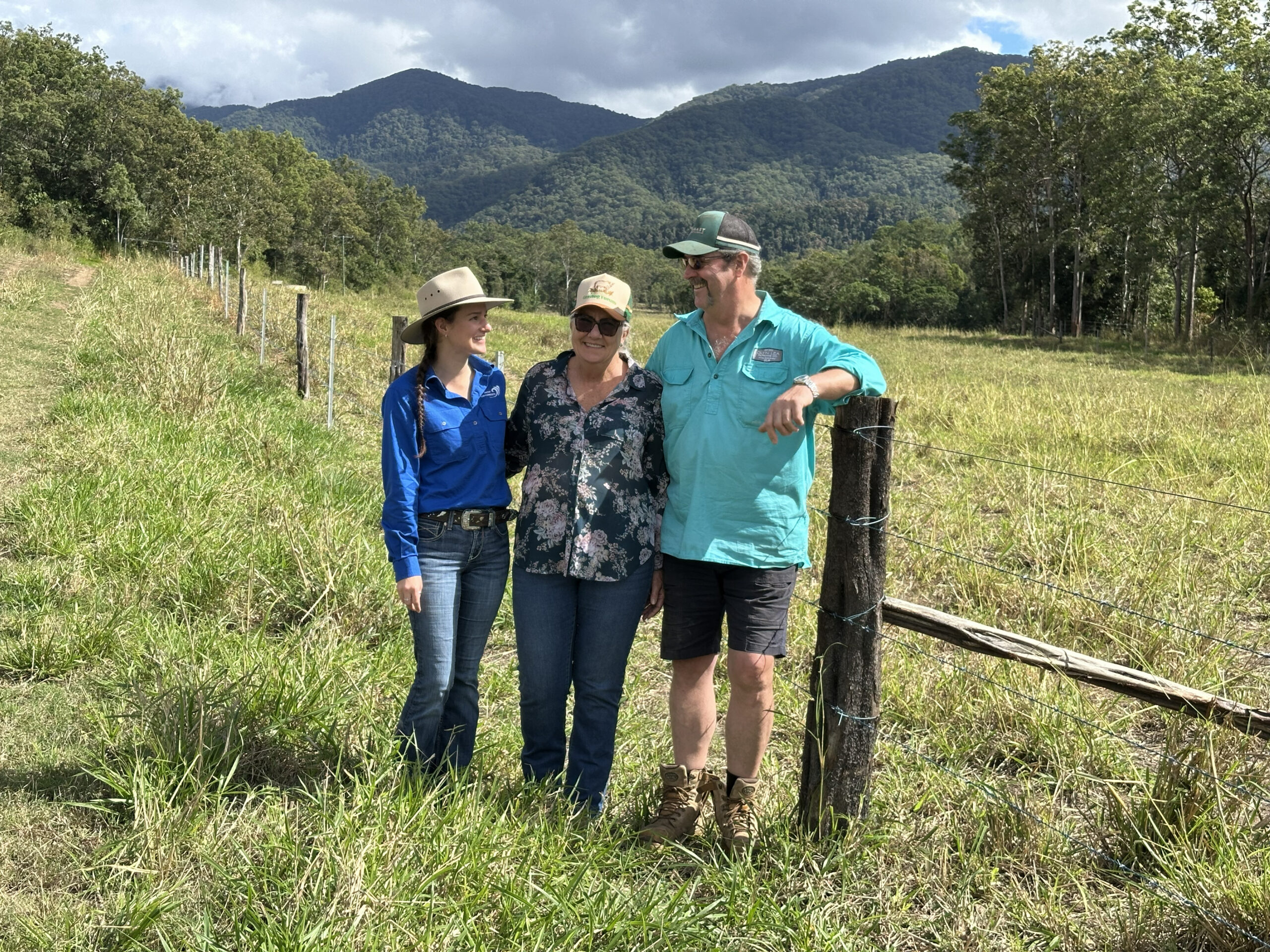 Reef Catchments female staff member in a blue short chatting with Owen and Penny by the fence